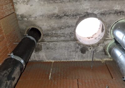 Groot gat in betonnen vloer naast andere buizen